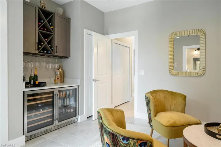 Bar featuring light tile patterned floors and beverage cooler