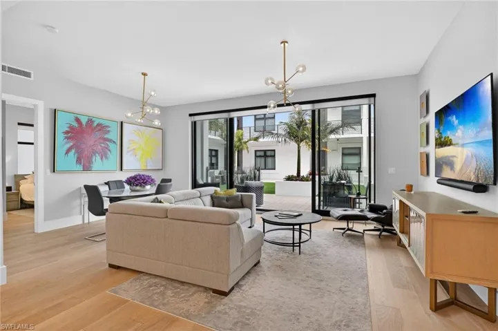 Living area with a chandelier and light wood-style flooring