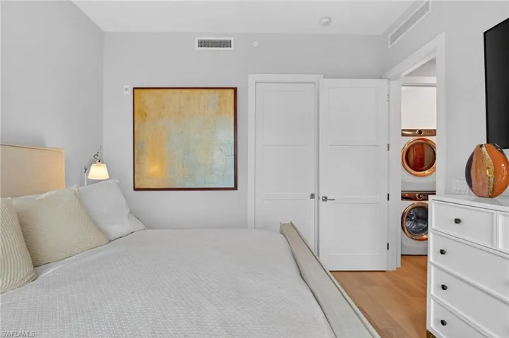 Bedroom with washer / dryer and light wood-style flooring