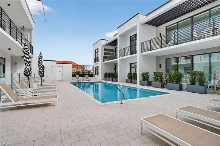 Community pool featuring a balcony and a patio area