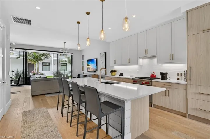Kitchen with light brown cabinets, white cabinetry, and recessed lighting