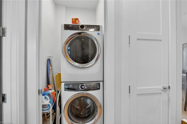 Washroom with stacked washer and clothes dryer