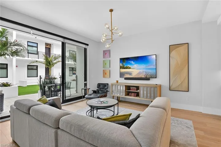 Living area featuring light wood finished floors and a chandelier