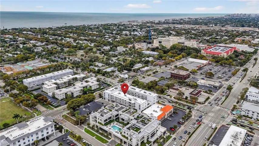 Aerial view of property and surrounding area featuring nearby urban area and a nearby body of water