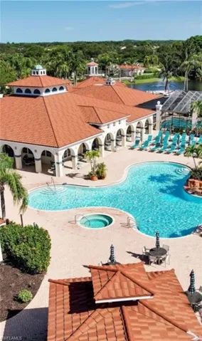 Pool with a patio area and a hot tub