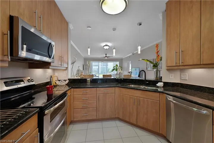 Kitchen featuring Stainless Steel Appliances, Crown Molding, Granite  Countertops, and Decorative Light Fixtures