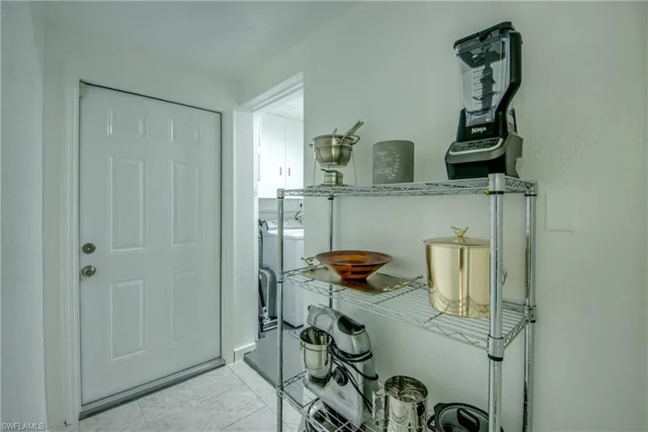 Entryway featuring independent washer and dryer and light tile floors