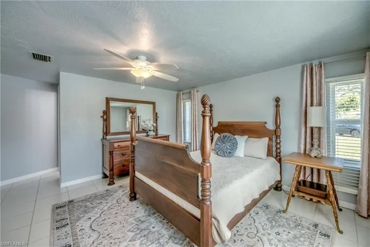 Tiled bedroom with ceiling fan and a textured ceiling