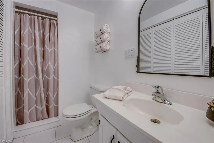 Bathroom with tile flooring, vanity, and toilet