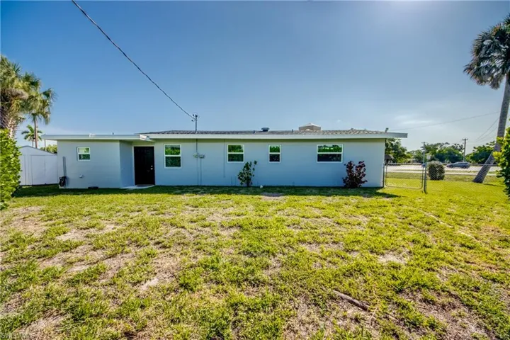 Rear view of property with a lawn