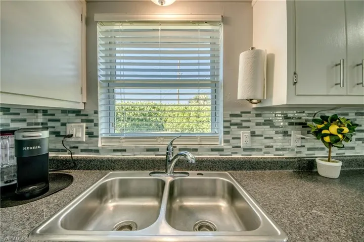 Kitchen featuring sink, white cabinets, and tasteful backsplash