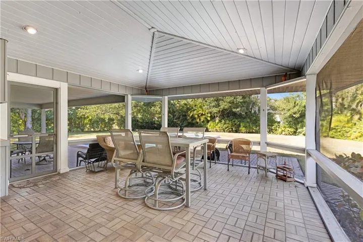 Sunroom featuring outdoor dining space, brick patterned floors, wood ceiling, and a patio