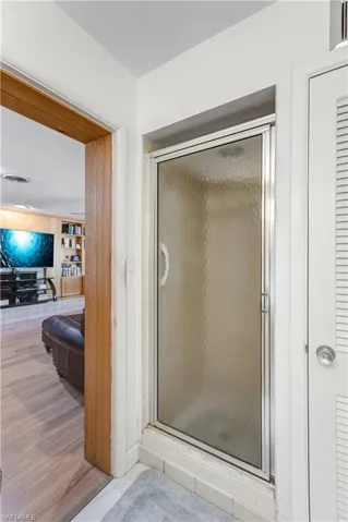Full bath featuring a shower stall and wood finished floors
