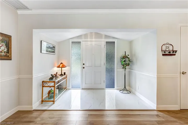 Foyer featuring crown molding and hardwood / wood-style floors