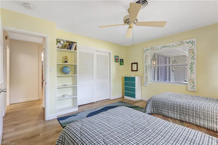Bedroom featuring light wood-style floors, a ceiling fan, and a closet