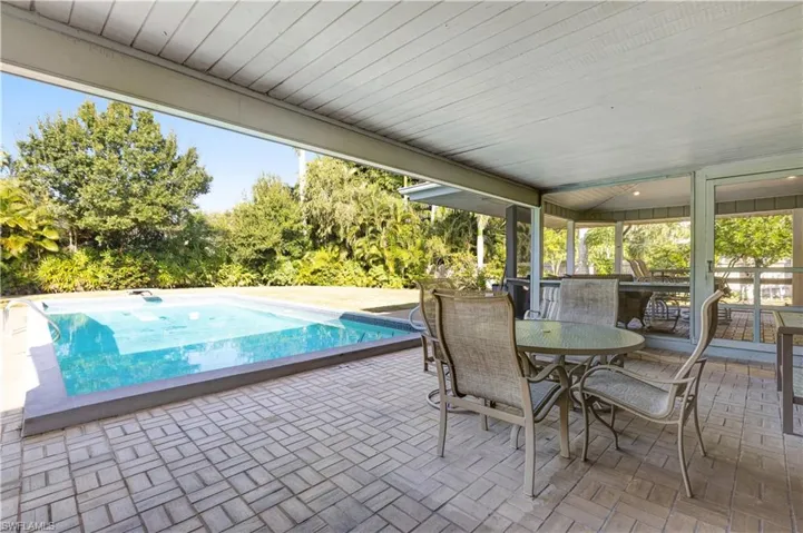 Swimming pool with outdoor dining space and a patio area