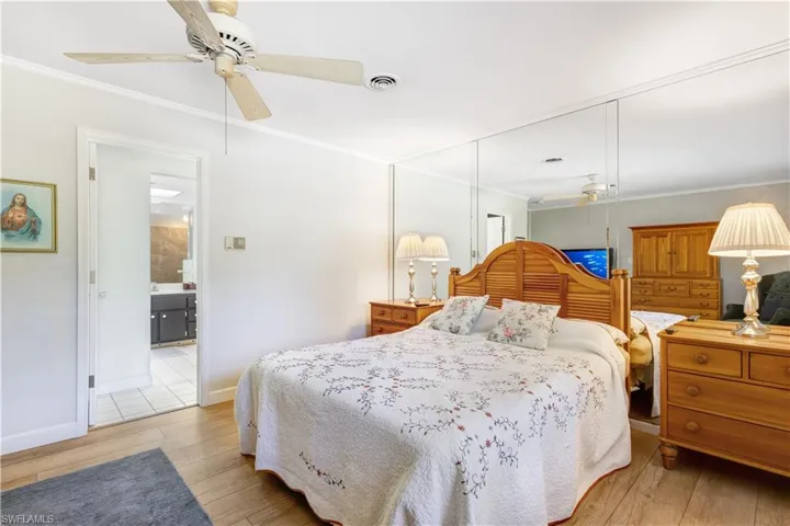 Bedroom with a ceiling fan, light wood finished floors, and ornamental molding