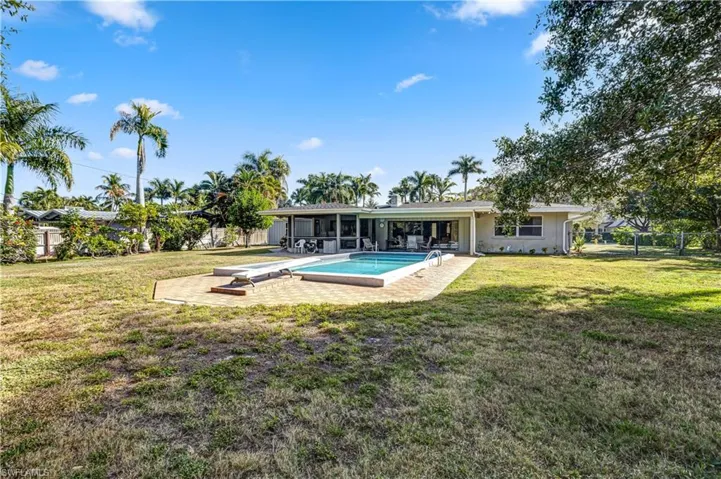 Rear view of property with a patio area, an outdoor pool, and a fenced backyard