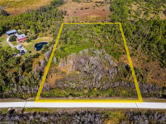 Aerial view of sparsely populated area with property parcel outlined