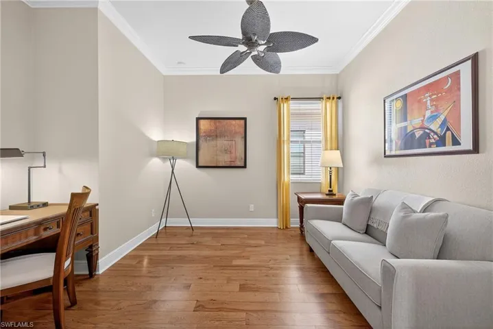 Versatile den with hardwood floors and ceiling fan, suitable as office, media room, or 4th bedroom