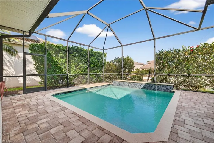 Southwestern-exposure screened lanai featuring heated pool, water features, lake views, and enhanced tropical landscaping for privacy