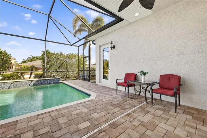 Southwestern-exposure screened lanai featuring heated pool, water features, lake views, and enhanced tropical landscaping for privacy