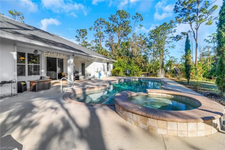 View of swimming pool featuring a patio and a pool with connected hot tub