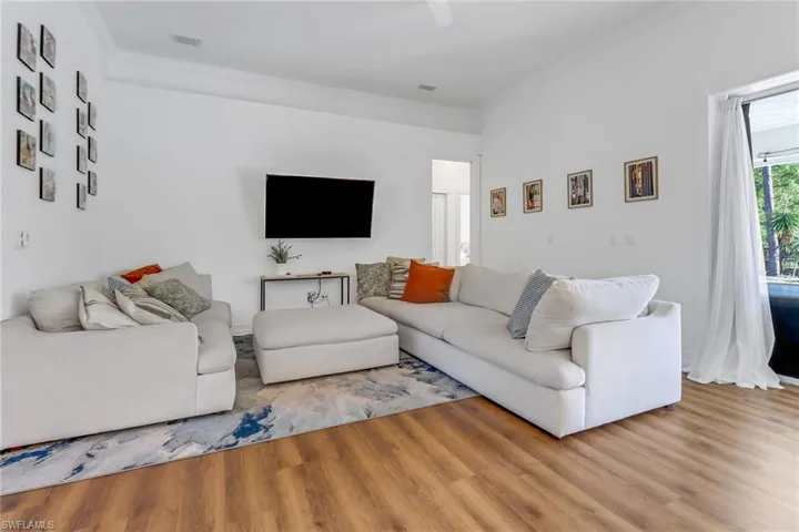 Living area featuring crown molding, wood finished floors, and visible vents