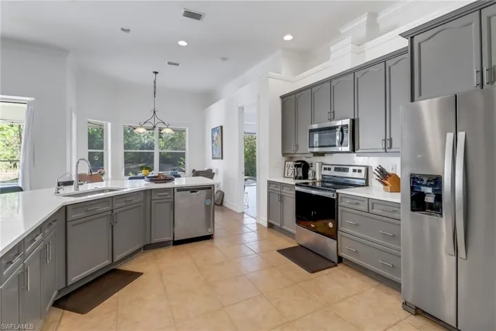 Kitchen with visible vents, light countertops, a sink, gray cabinetry, and stainless steel appliances