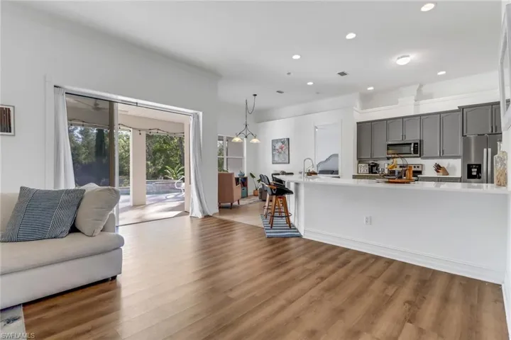 Living area with crown molding, recessed lighting, and wood finished floors
