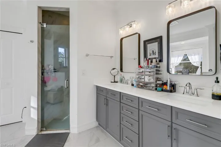 Full bath featuring a sink, baseboards, a shower stall, and marble finish floor