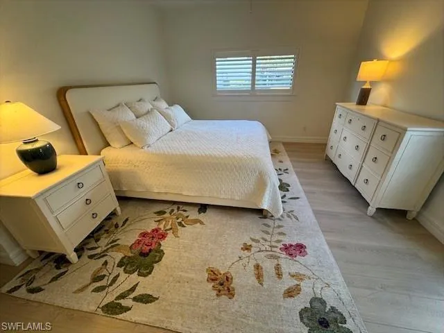 Guest Bedroom #2 Suite with light wood-style floors and baseboards