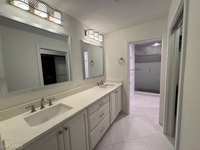 Full bathroom featuring double vanity and light tile patterned floors