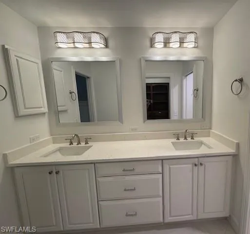 Full bath with double vanity and light tile patterned floors