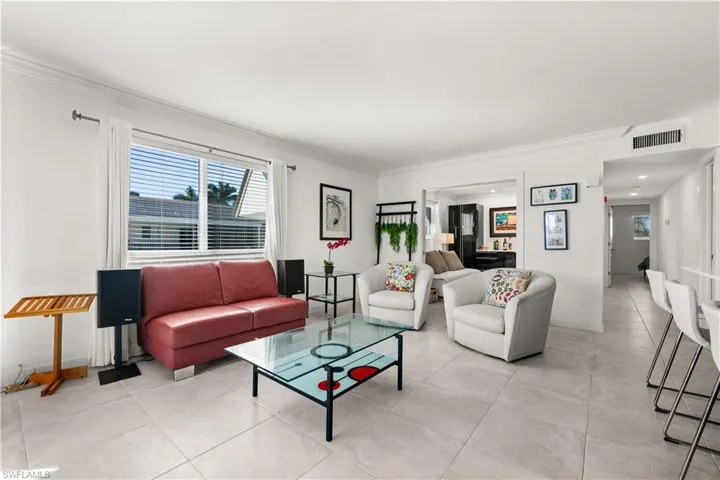 Living area with ornamental molding and light tile patterned floors