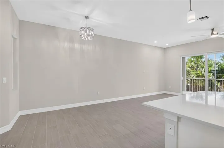 Unfurnished dining area with wood tiled floors, a ceiling fan, and hanging lights