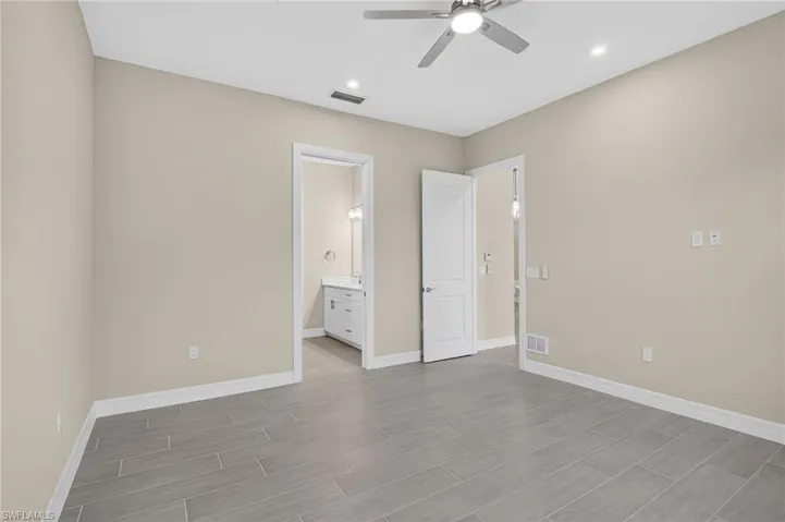 Unfurnished bedroom with ceiling fan, connected bathroom, wood tiled floors, and recessed lighting