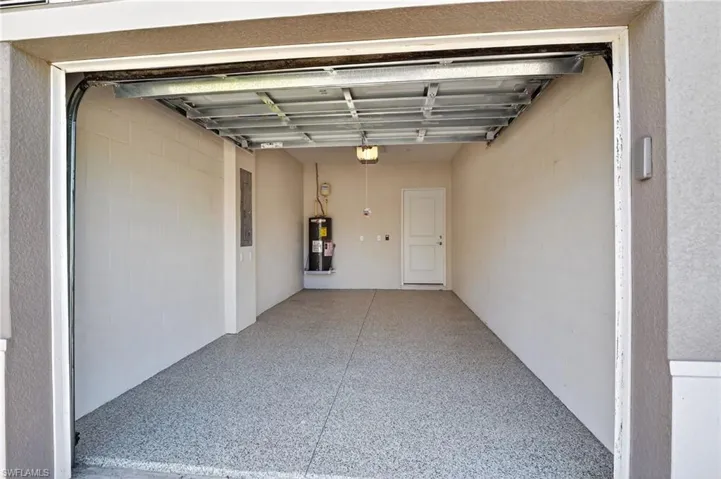Garage featuring water heater and concrete block wall