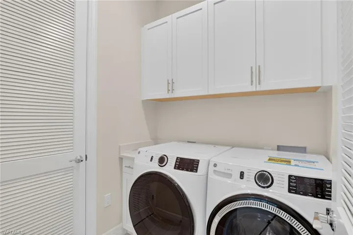 Laundry area with cabinet space and washer and clothes dryer