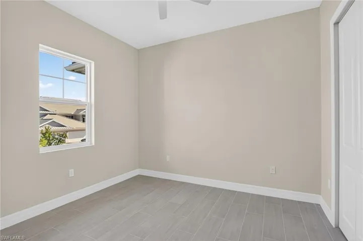 Empty room with a ceiling fan and wood tiled floors