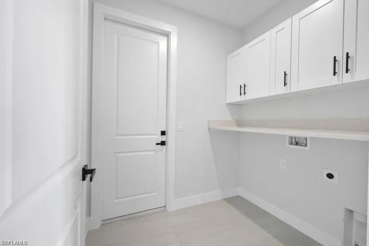 Laundry room with washer hookup, cabinet space, baseboards, and electric dryer hookup