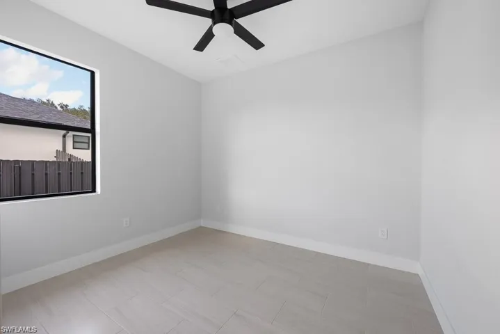 Empty room featuring baseboards and ceiling fan