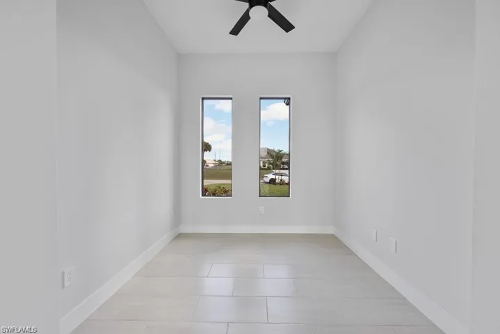 Spare room with baseboards and a ceiling fan