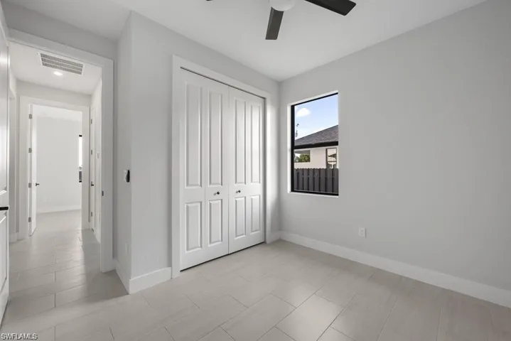 Unfurnished bedroom featuring a closet, visible vents, a ceiling fan, and baseboards