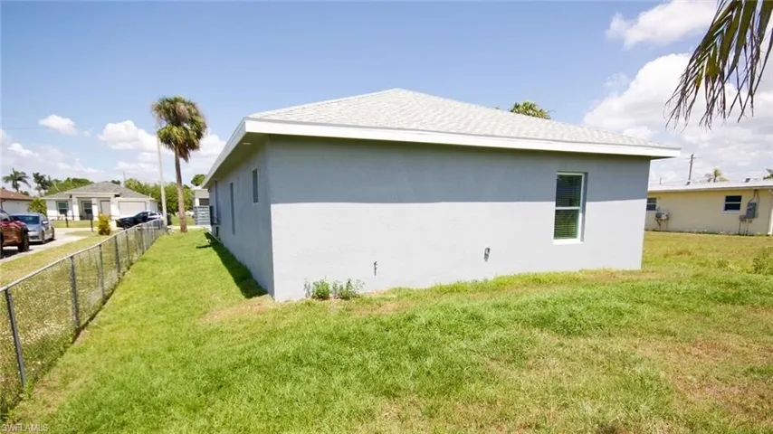Single-story home featuring a light gray stucco exterior and a white shingle roof