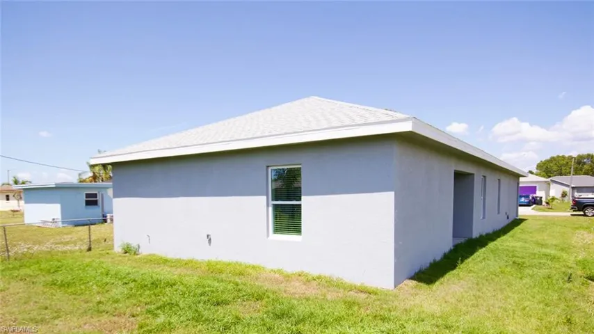 Contemporary single-story residence with a light gray stucco exterior and a white shingle roof