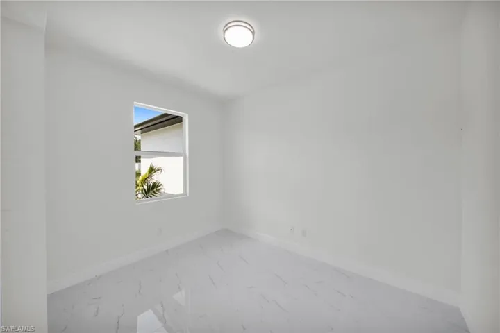 Unfurnished room with light marble finish flooring and baseboards