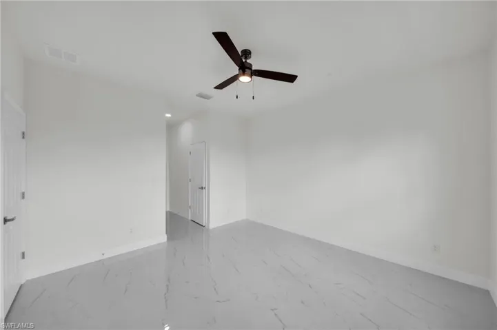 Unfurnished room with ceiling fan and marble finish flooring