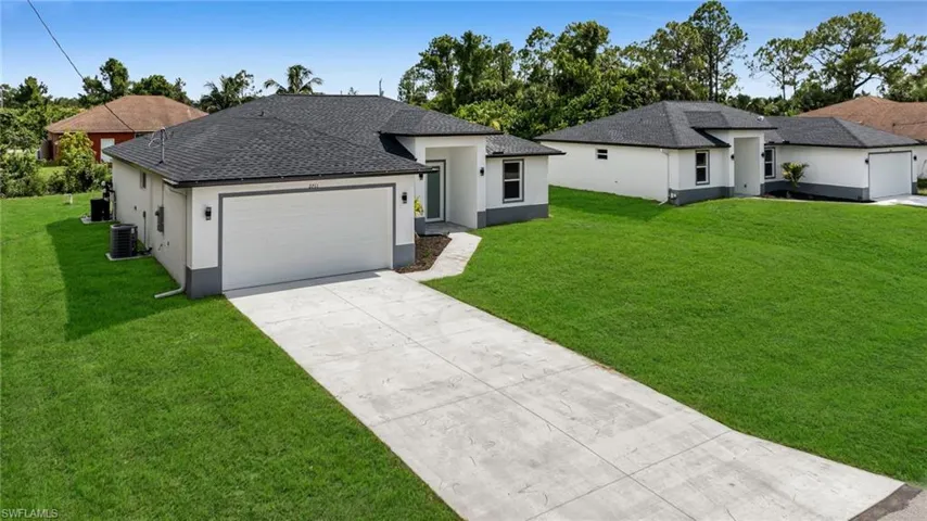 Prairie-style house with a front lawn, stucco siding, and concrete driveway