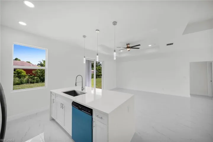 Kitchen with dishwashing machine, light marble finish floors, recessed lighting, white cabinets, and ceiling fan